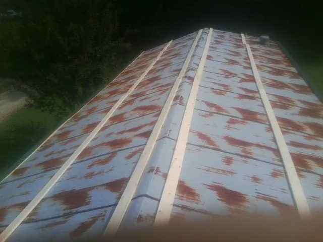Rusted metal roof panels with new wood purlins before replacement — Storm Damage Roof Repair in New Athens by Roofing Brothers
